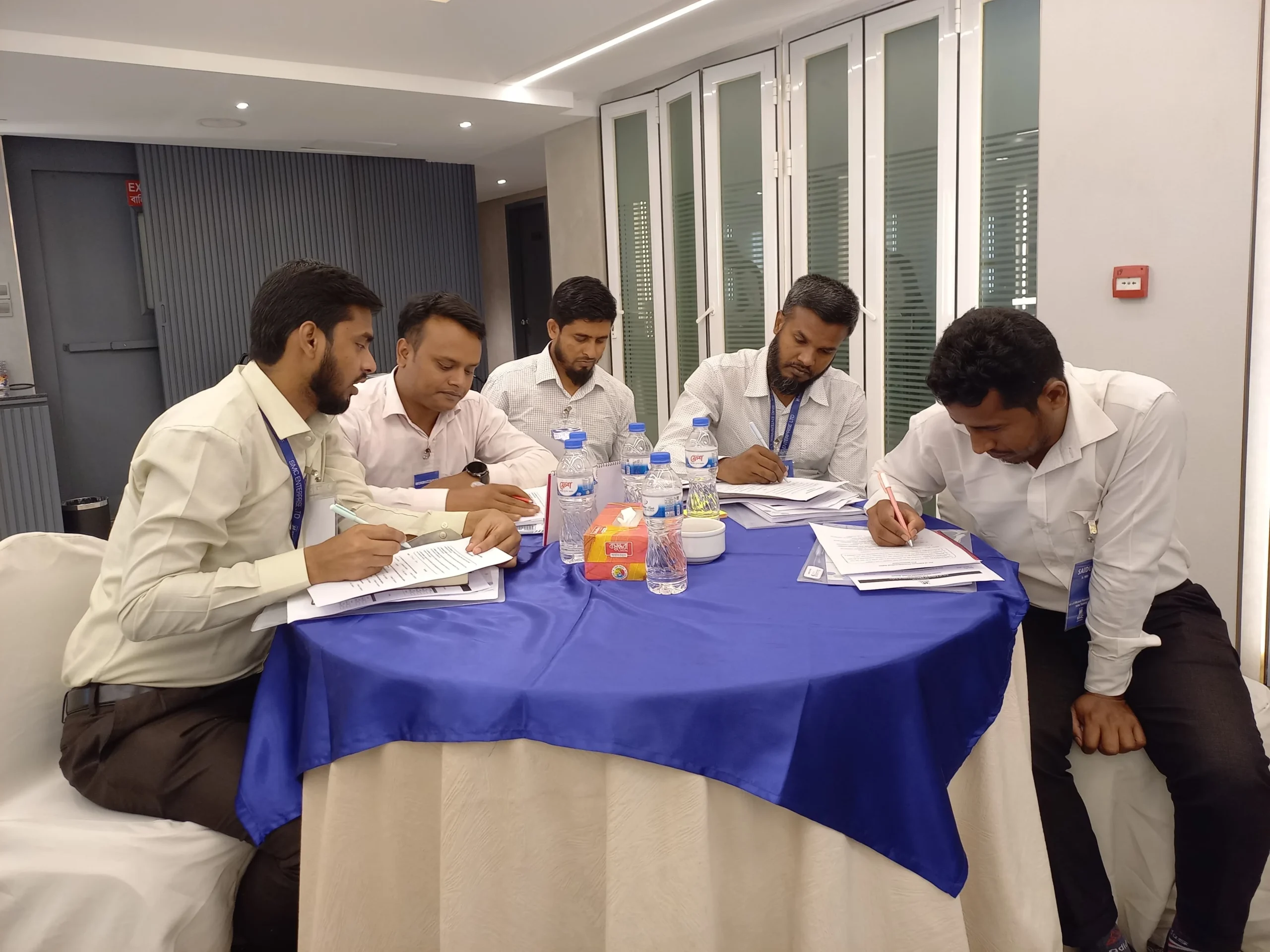 Sales professionals working together on training materials and case studies during workshop Bangladesh
